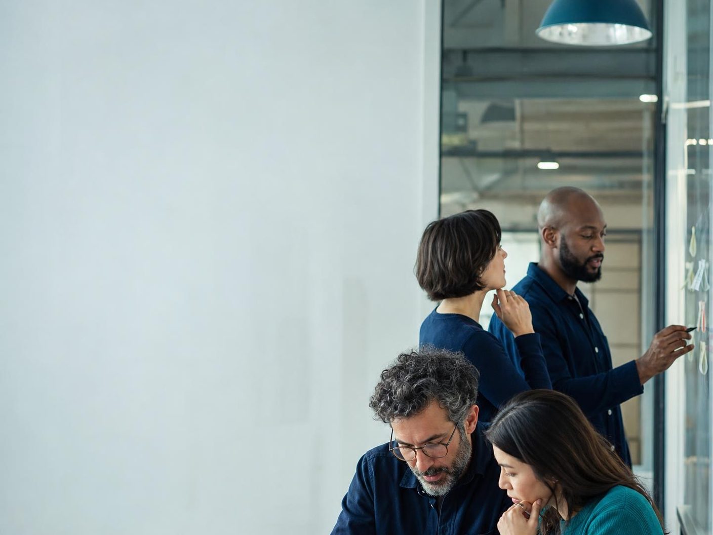 A research team at work in an open office with charts on screen