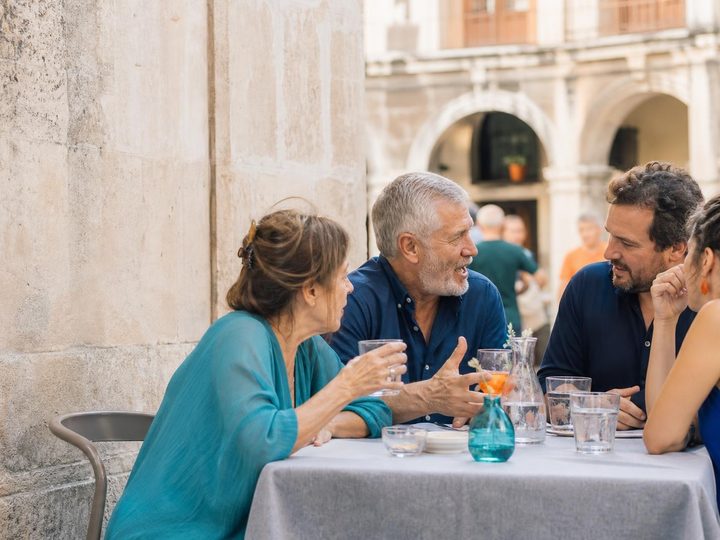 A group of friends talk on a terrace