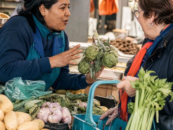 A vendor serves a customer at a market